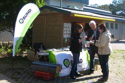 Menschen stehen vor einem Infostand des BUND.